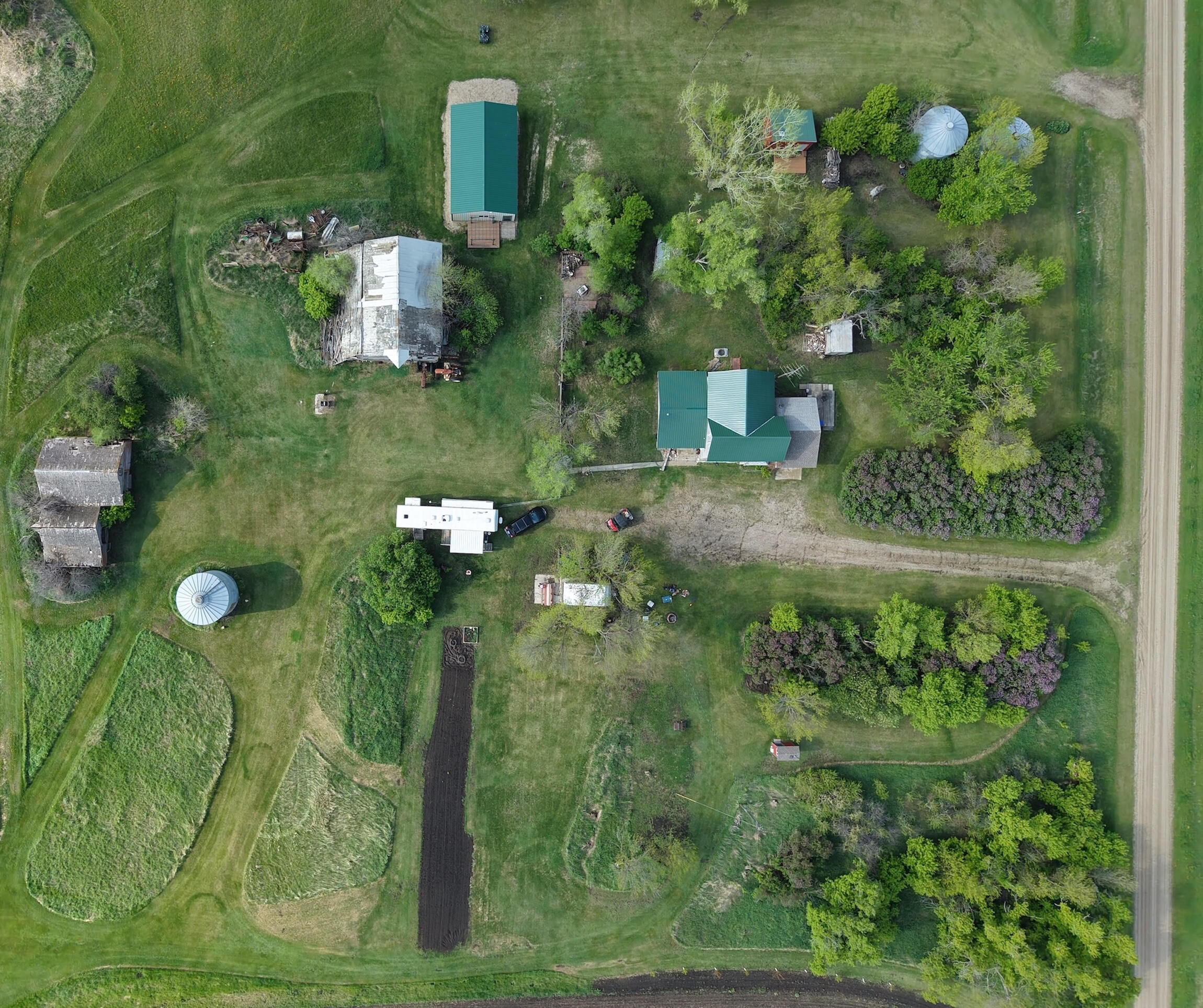 Picture of an aging farmstead with a house, barn, garden, and other structures.