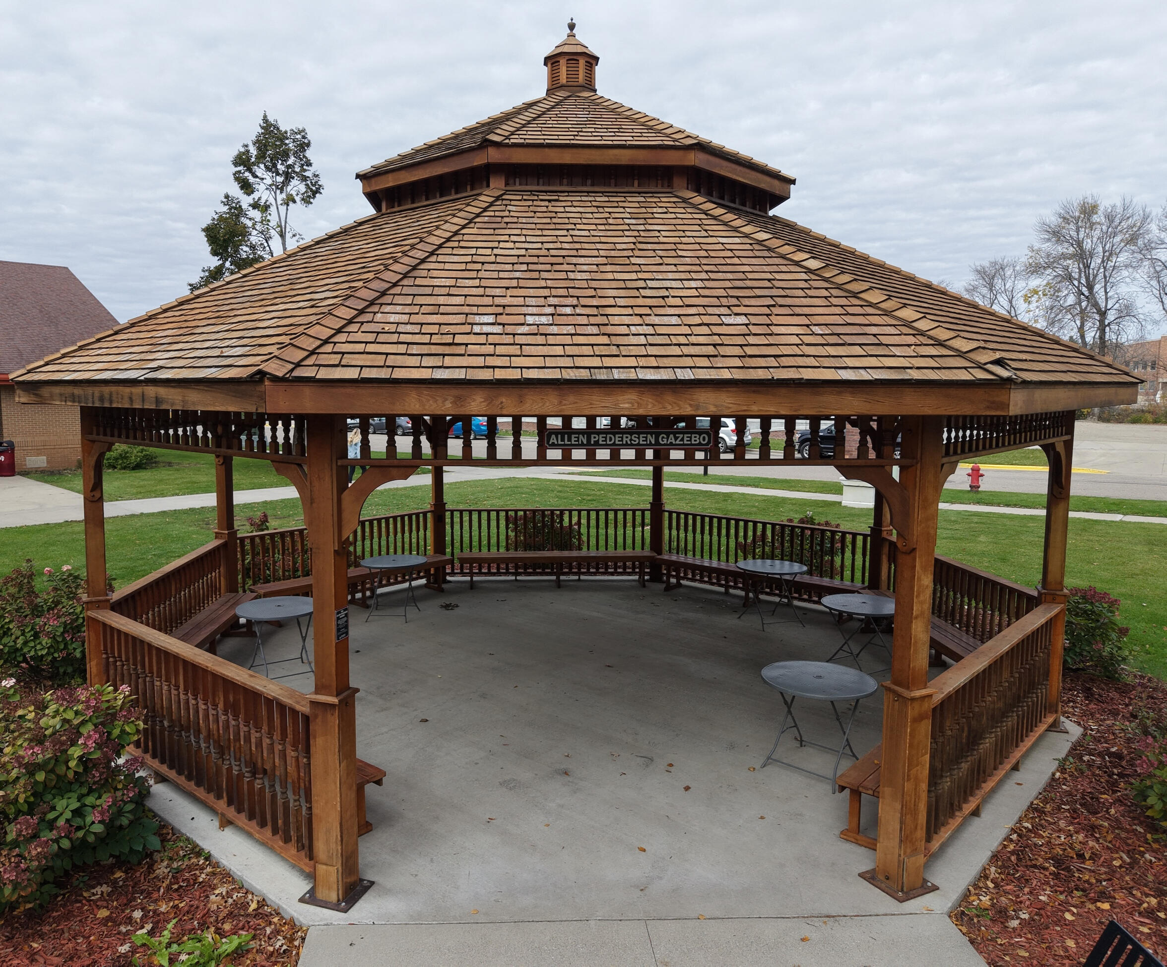 Picture of grassy area with trees and a gazebo.